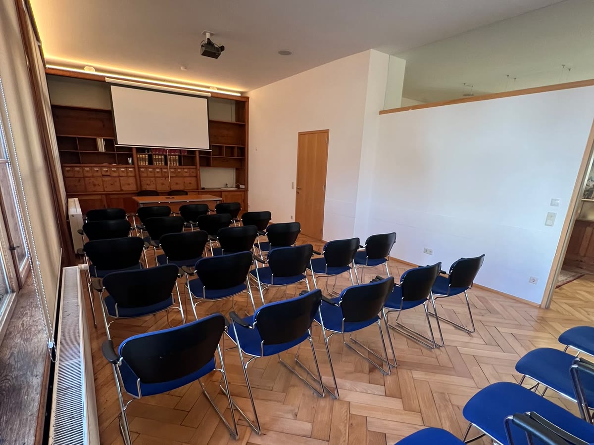 Der Seminarraum mit Bestuhlung, Leinwand und Fischgrätparkett
